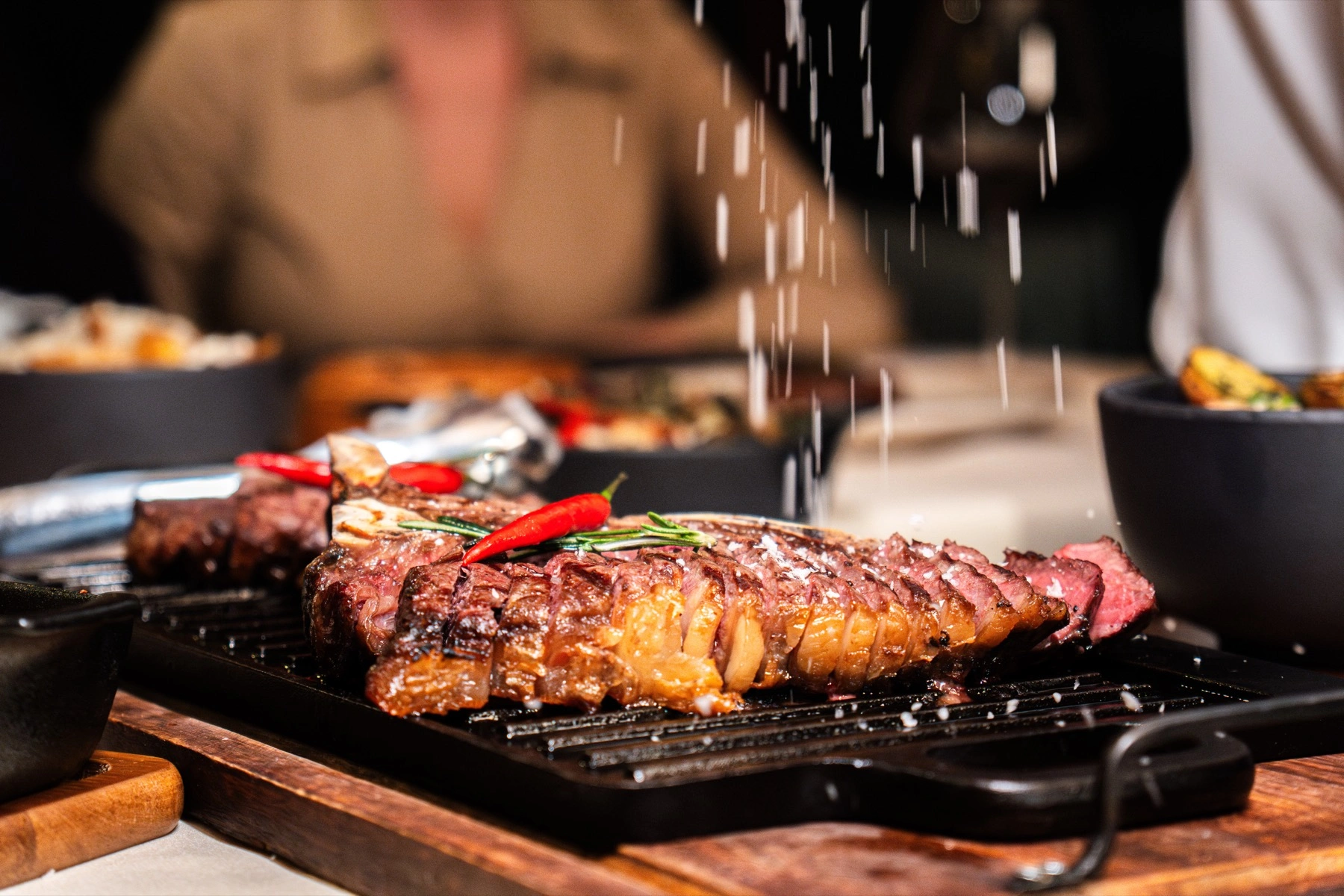 Prostřený stůl se svíčkami a sklenicemi v komorním interiéru restaurace